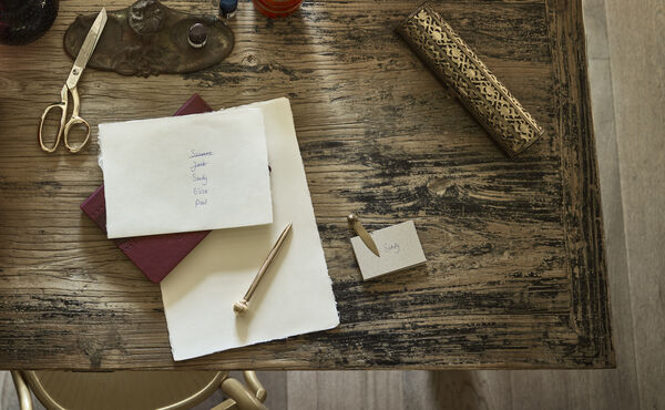 Holiday planning list and place card on a rustic desk – a mindful approach to reducing seasonal stress and staying organised.